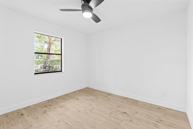 spare room featuring ceiling fan, baseboards, and light wood-style floors
