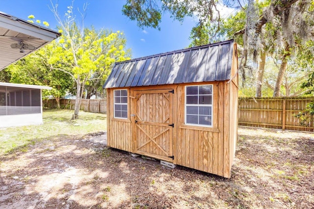 view of shed featuring a fenced backyard and a sunroom