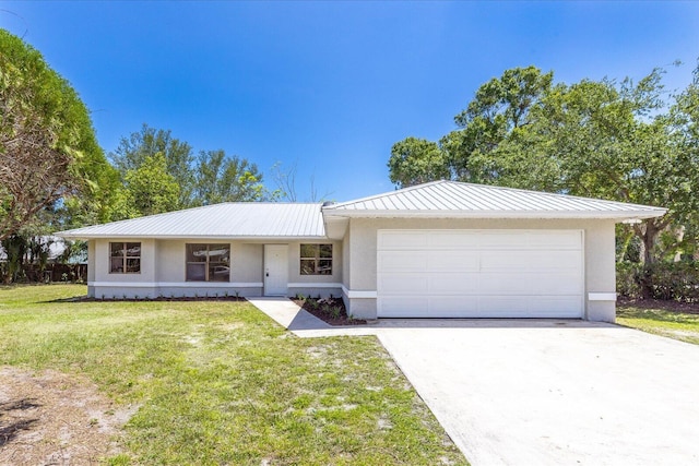 ranch-style home with metal roof, concrete driveway, an attached garage, a front yard, and stucco siding