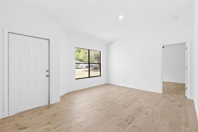 interior space featuring recessed lighting, light wood-style floors, lofted ceiling, and baseboards