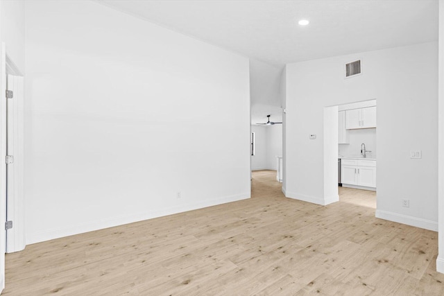 unfurnished bedroom featuring a sink, light wood-style flooring, baseboards, visible vents, and recessed lighting