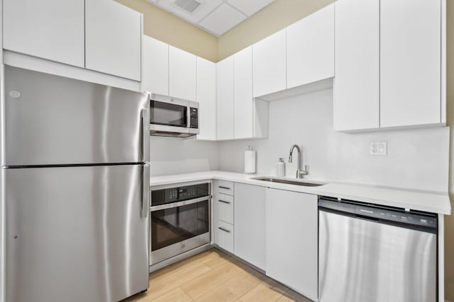 1370 S Ocean Blvd Unit 1808, Pompano Beach, FL 33062 - kitchen featuring stainless steel appliances, light countertops, white cabinetry, and light wood-style flooring