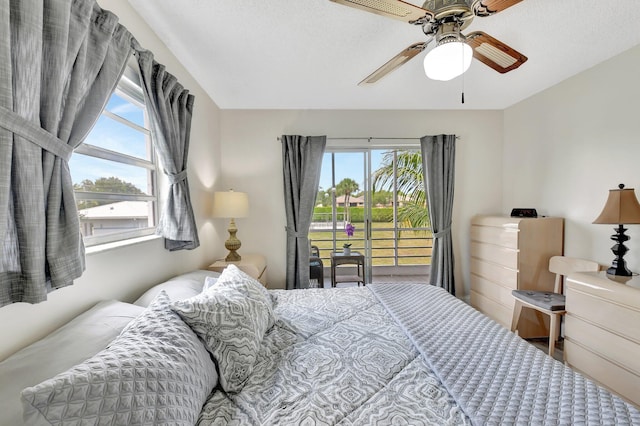 bedroom featuring a ceiling fan, access to outside, and multiple windows