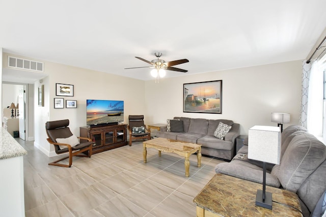 living room with ceiling fan, baseboards, visible vents, and light tile patterned floors
