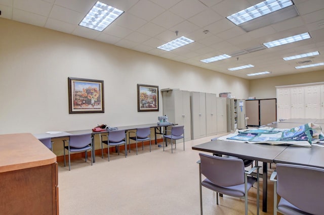 home office with a paneled ceiling and light colored carpet