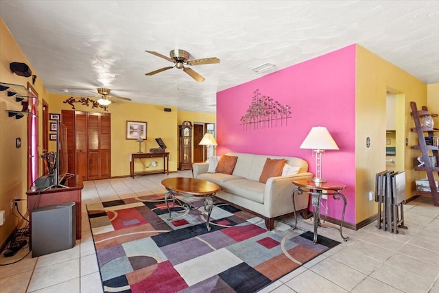 tiled living area featuring visible vents, ceiling fan, and baseboards