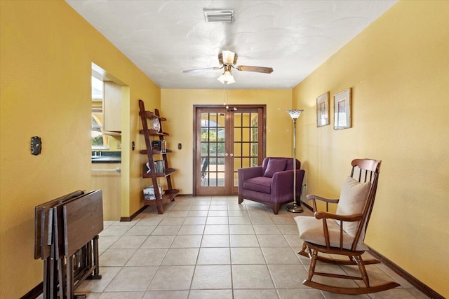 living area with light tile patterned floors, baseboards, visible vents, a ceiling fan, and french doors