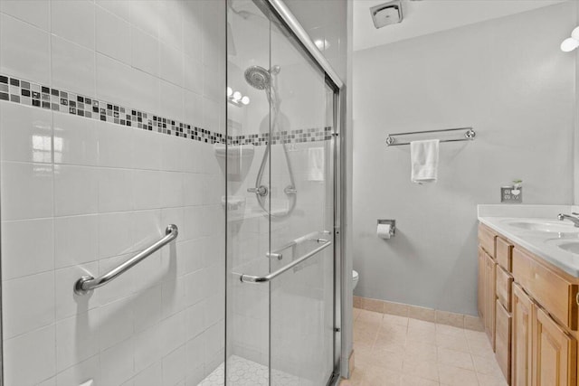 full bathroom with a shower stall, double vanity, and a sink