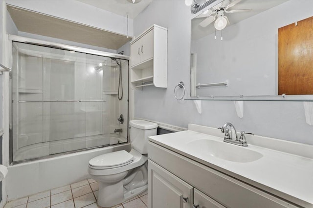 bathroom with vanity, bath / shower combo with glass door, tile patterned floors, toilet, and a ceiling fan