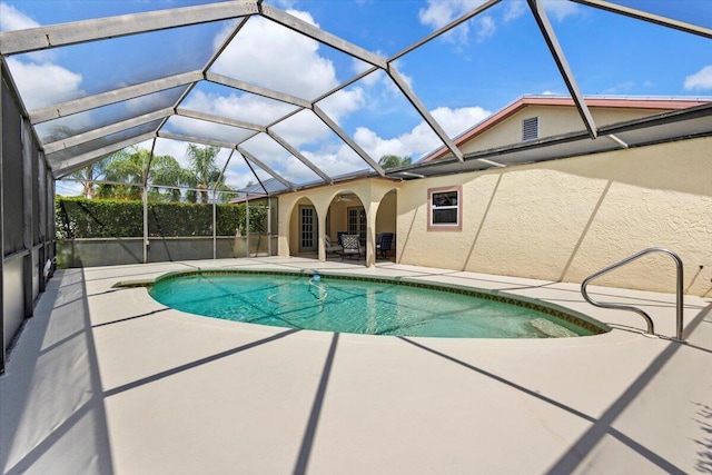outdoor pool with a patio and glass enclosure