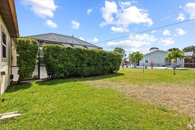 view of yard featuring fence and a lanai