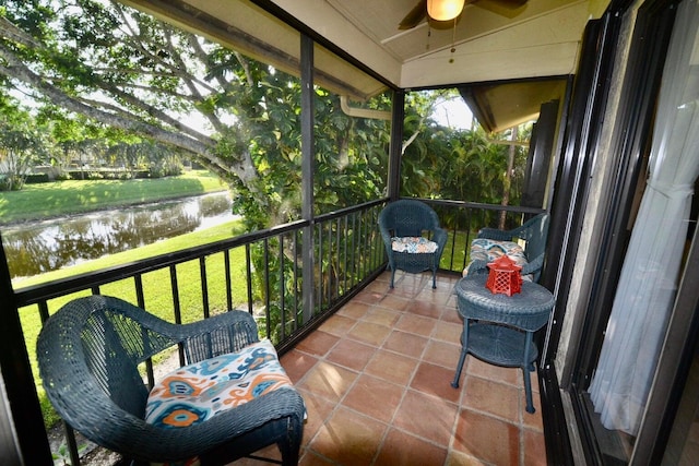balcony with ceiling fan and a water view