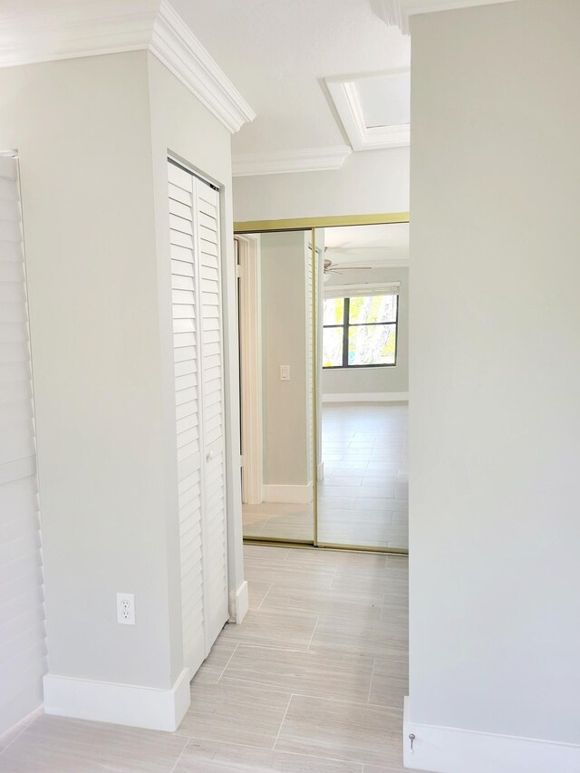 corridor with baseboards and ornamental molding