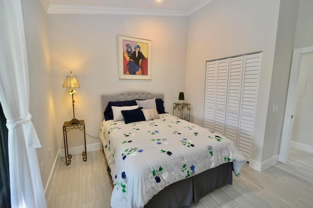 bedroom featuring crown molding, baseboards, and a closet
