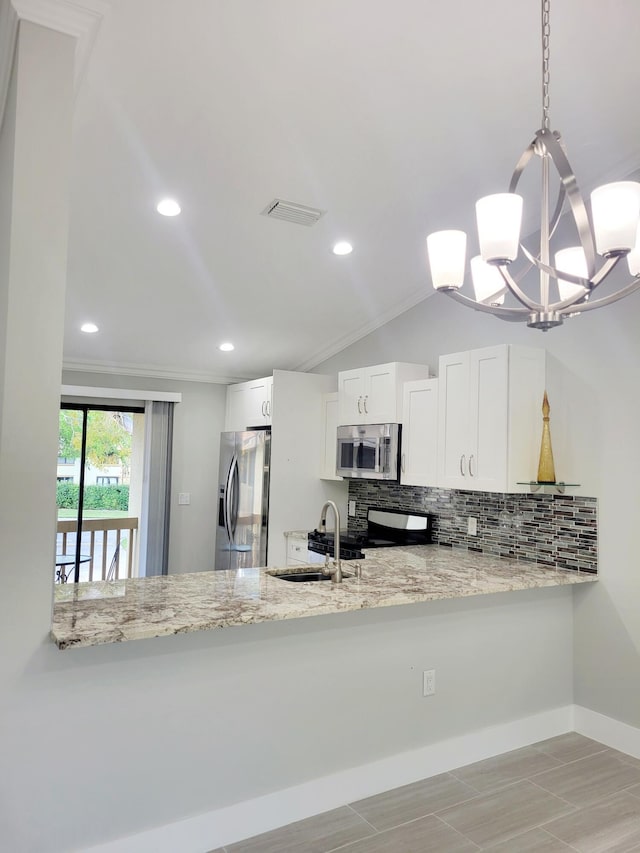 kitchen featuring a sink, a peninsula, stainless steel appliances, and visible vents