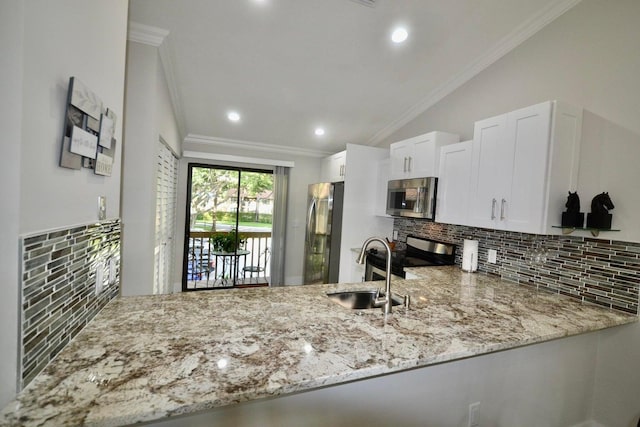 kitchen featuring tasteful backsplash, crown molding, a sink, appliances with stainless steel finishes, and a peninsula