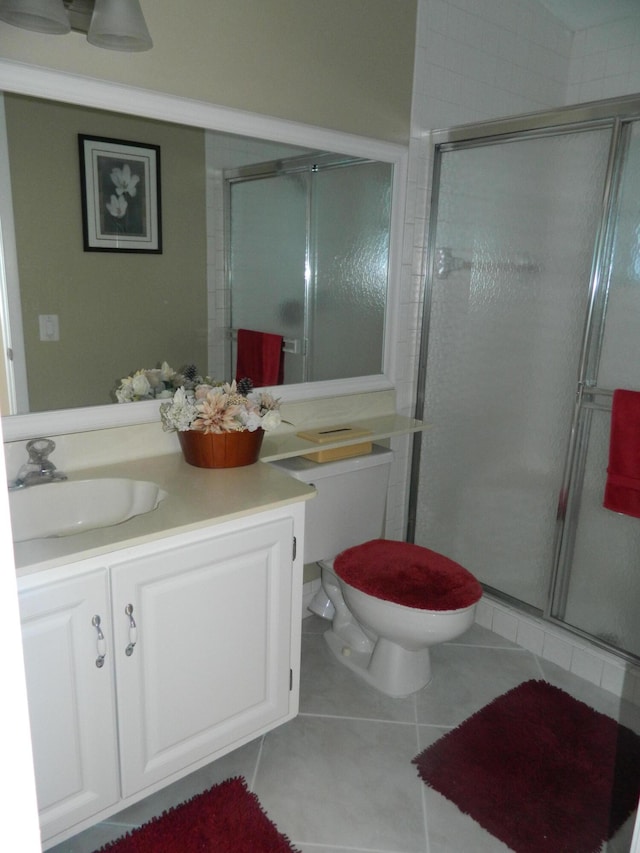 bathroom with tile patterned floors, a shower stall, toilet, and vanity