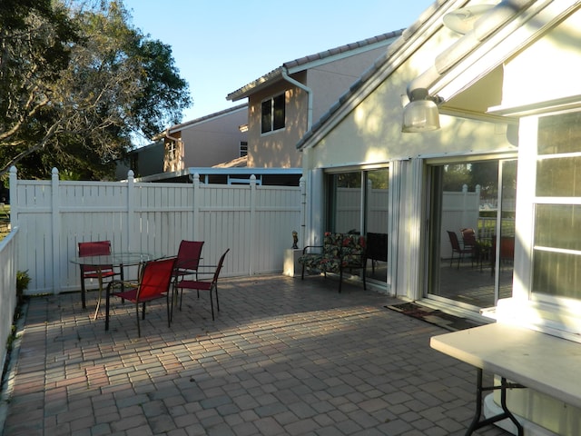 view of patio featuring outdoor dining space and fence