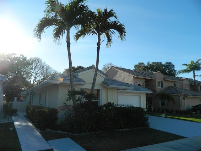 view of side of property featuring an attached garage and stucco siding