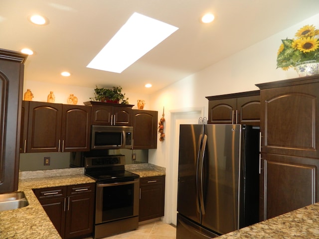 kitchen featuring dark brown cabinetry, stainless steel appliances, lofted ceiling with skylight, and recessed lighting