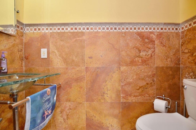 283 NE Sagamore Terrace, Port Saint Lucie, FL 34983 - bathroom with toilet, tile walls, and a sink