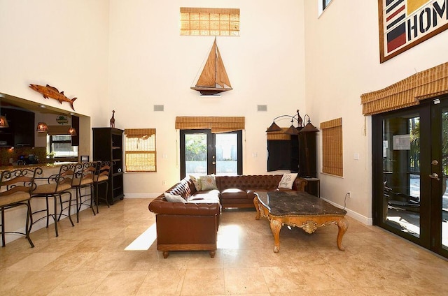 283 NE Sagamore Terrace, Port Saint Lucie, FL 34983 - living room featuring a towering ceiling, visible vents, and baseboards