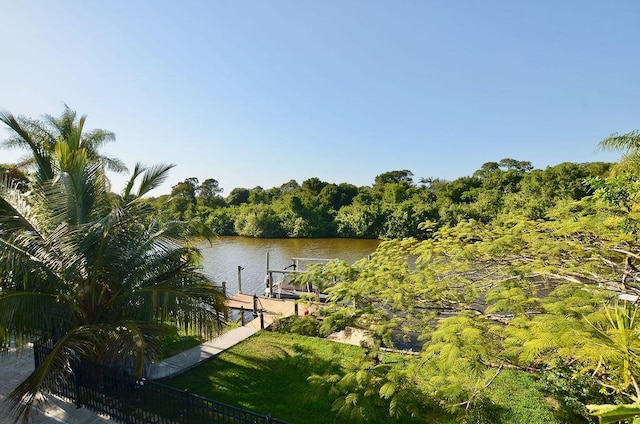 283 NE Sagamore Terrace, Port Saint Lucie, FL 34983 - view of dock featuring fence, a water view, and a forest view