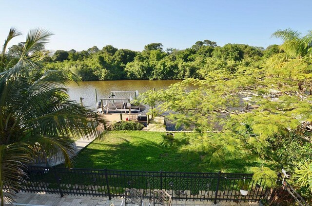 283 NE Sagamore Terrace, Port Saint Lucie, FL 34983 - view of dock with fence, a yard, and a water view