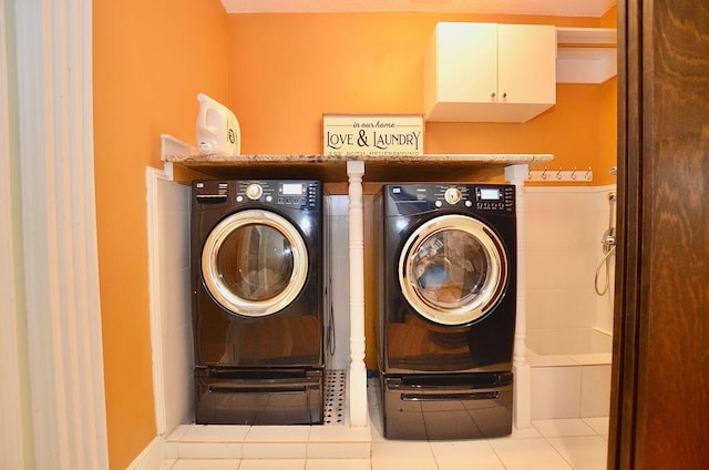283 NE Sagamore Terrace, Port Saint Lucie, FL 34983 - laundry room with tile patterned floors, cabinet space, and washing machine and dryer