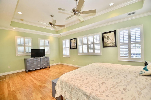 283 NE Sagamore Terrace, Port Saint Lucie, FL 34983 - bedroom featuring a tray ceiling, crown molding, visible vents, baseboards, and wood finished floors