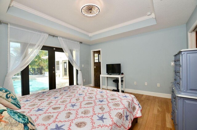 283 NE Sagamore Terrace, Port Saint Lucie, FL 34983 - bedroom with crown molding, access to exterior, light wood-style flooring, and a raised ceiling