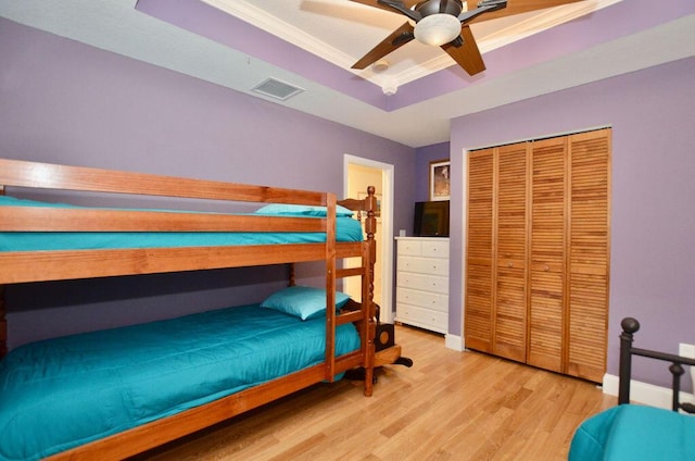 283 NE Sagamore Terrace, Port Saint Lucie, FL 34983 - bedroom featuring a closet, light wood finished floors, visible vents, a ceiling fan, and a tray ceiling