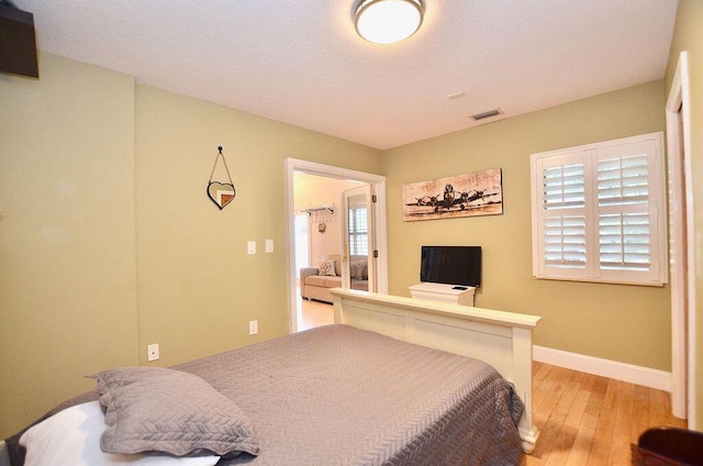 283 NE Sagamore Terrace, Port Saint Lucie, FL 34983 - bedroom featuring baseboards, visible vents, and light wood finished floors