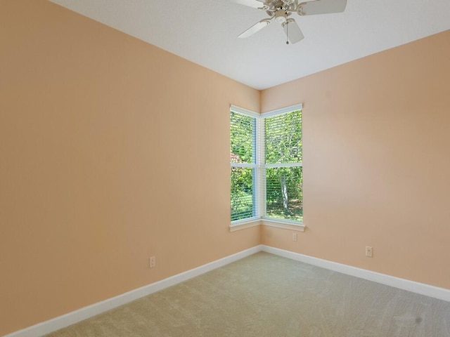 empty room with ceiling fan, baseboards, light colored carpet, and a wealth of natural light