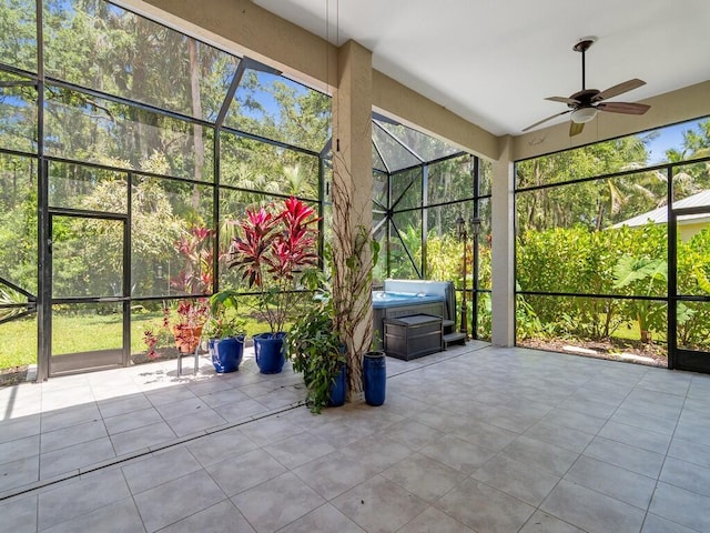 unfurnished sunroom with a ceiling fan and a jacuzzi