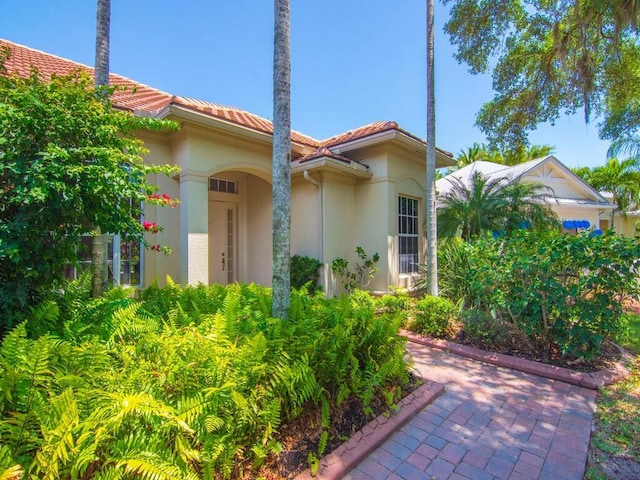 exterior space with stucco siding and a tiled roof