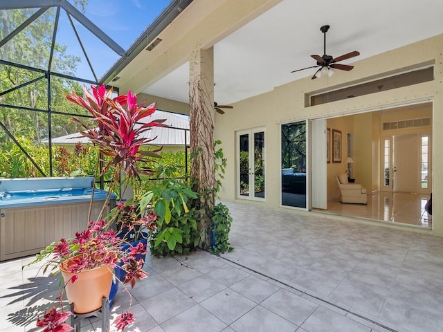 view of patio / terrace featuring a hot tub, ceiling fan, french doors, and glass enclosure
