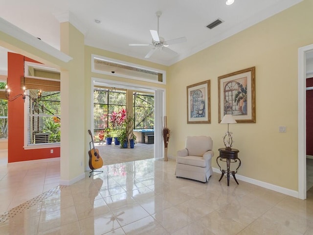 sitting room with crown molding, ceiling fan, baseboards, light tile patterned floors, and visible vents