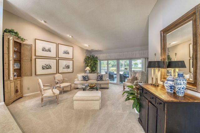 living area with lofted ceiling, light carpet, and baseboards