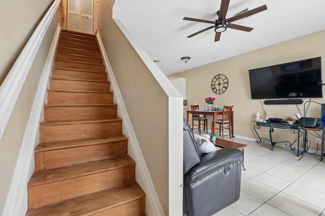stairs with tile patterned floors, a ceiling fan, and visible vents