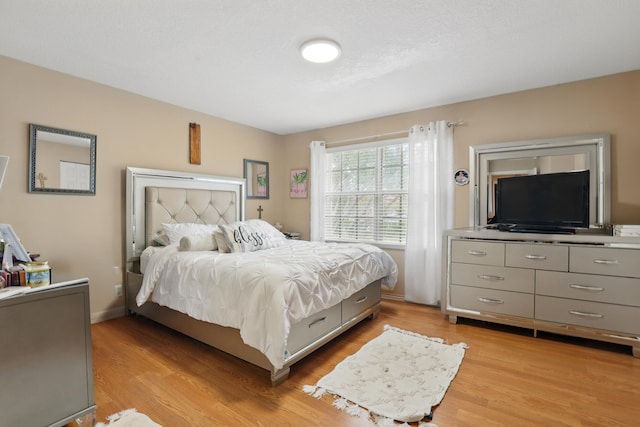 bedroom with light wood-style flooring and baseboards