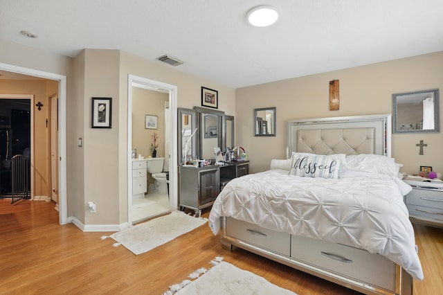 bedroom with baseboards, wood finished floors, and visible vents