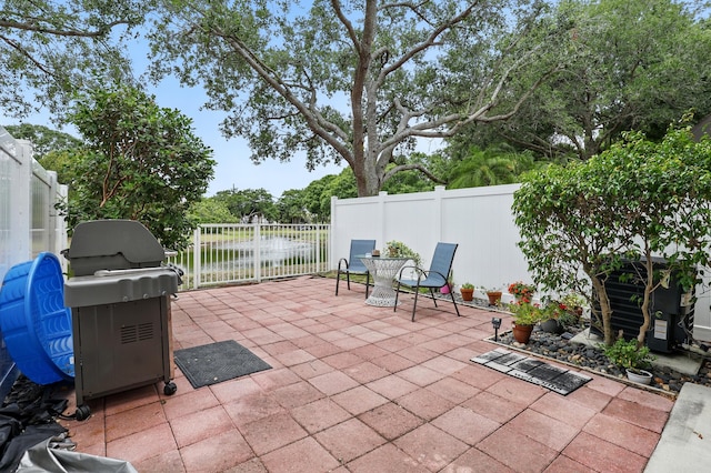 view of patio with grilling area, a fenced backyard, and outdoor dining space