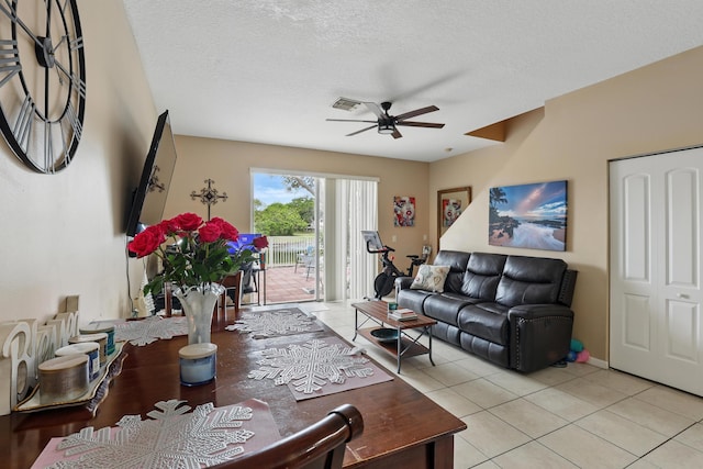 living area featuring light tile patterned flooring, a textured ceiling, visible vents, and a ceiling fan