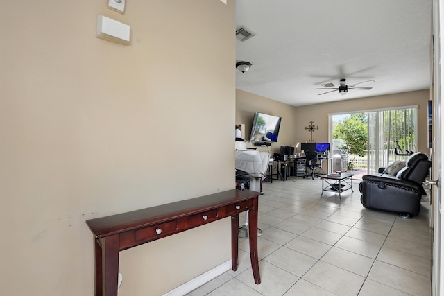 living area with a ceiling fan, visible vents, and light tile patterned floors