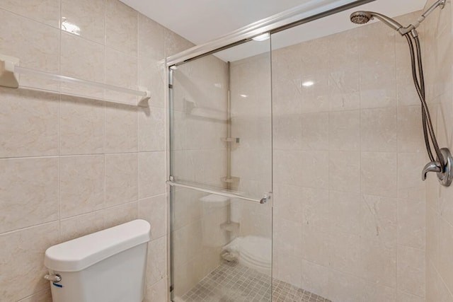 176 Lake Carol Dr, West Palm Beach, FL 33411 - full bath with a stall shower, tile walls, and toilet