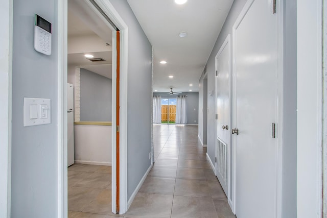 hallway with baseboards, visible vents, recessed lighting, and light tile patterned floors