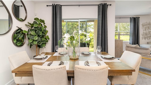 tiled dining space featuring baseboards
