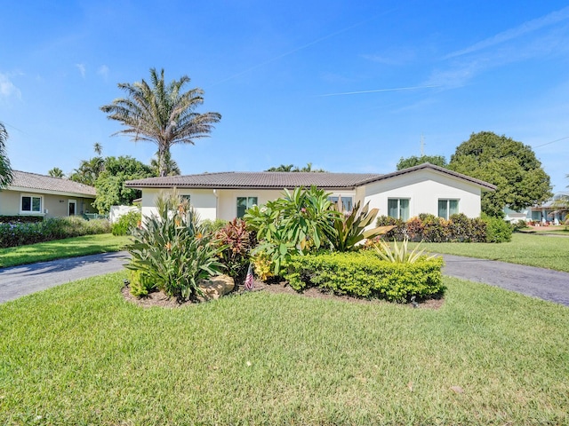 3821 NE 29th Ave, Lighthouse Point, FL 33064 - ranch-style house with a tiled roof, stucco siding, and a front yard