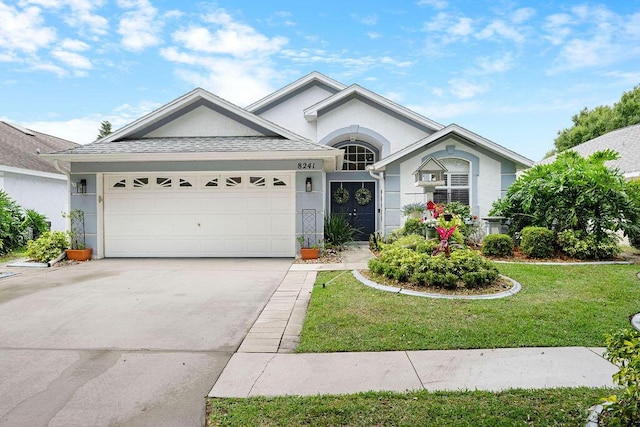 ranch-style home featuring a garage, stucco siding, a front yard, and driveway